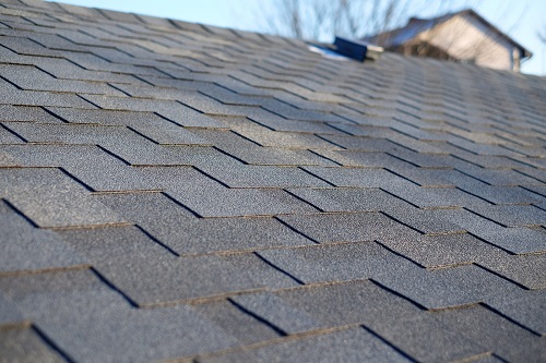 Bitumen tile roof. Roof Shingles - Hagerstown Roofing. Close up view on Asphalt Roofing Shingles .