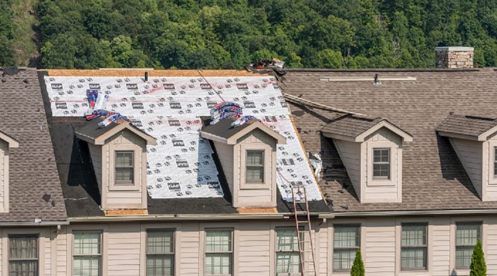 Morgantown, WV - 10 September 2020: Roofing contractor has laid waterproof liner on townhouse roof before adding the new shingles